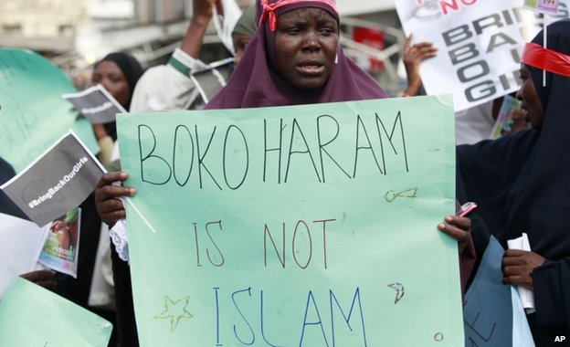 Mulher segura cartais com a frase "Boko Haram não é Islamismo" 
