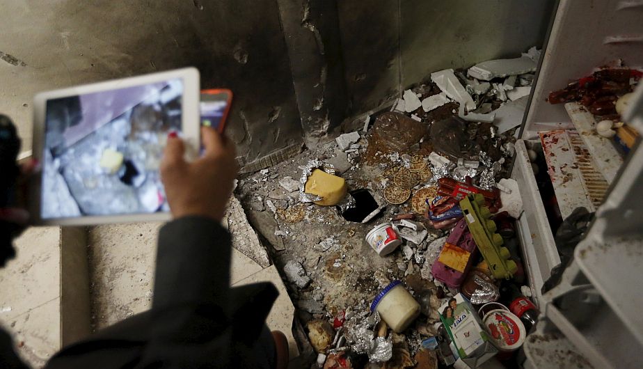 A journalist takes photographs of scattered food items in the kitchen at a safe house, where five people were shot dead during an operation to recapture the drug lord Joaquin "El Chapo" Guzman, at Jiquilpan Boulevard in Los Mochis in Sinaloa state, Mexico, January 11, 2016. REUTERS/Edgard Garrido