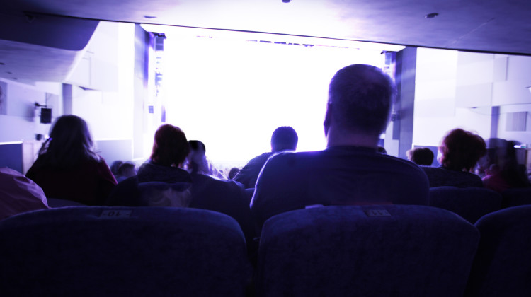 Group of people looking at clear white screen at cinema